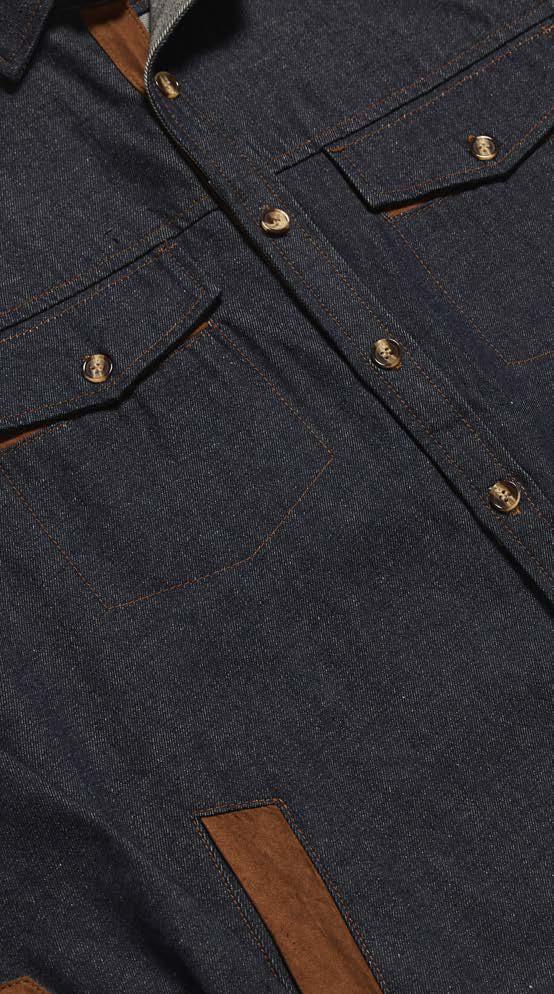 A man models the Inserch Denim Shirt Jacket w/ Suede Trim 2pc Set JS005-P005-00195 Indigo, paired with an orange-brown turtleneck sweater and brown shoes, standing against a beige background.