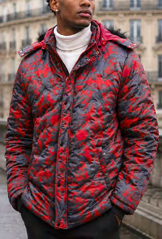 A person wears an INSOMNIA MZW-410 Soft Padded Poly Zip-up Jacket w/ Removable Red Faux Fur Hood in a red and gray pattern over a white turtleneck.