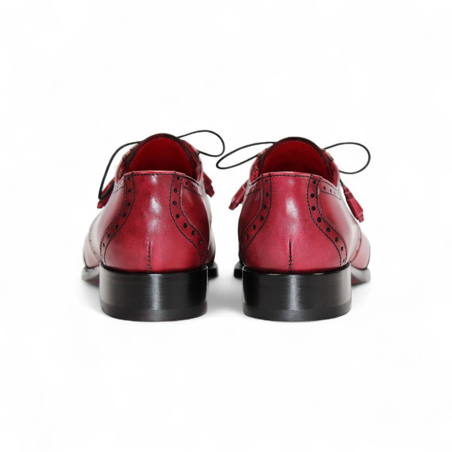 The Fennix Jax Antique Red by Fennix of Italy is a men's red leather dress shoe featuring decorative perforations, black laces, and a low black heel, exemplifying Italian craftsmanship and luxury on a white background.