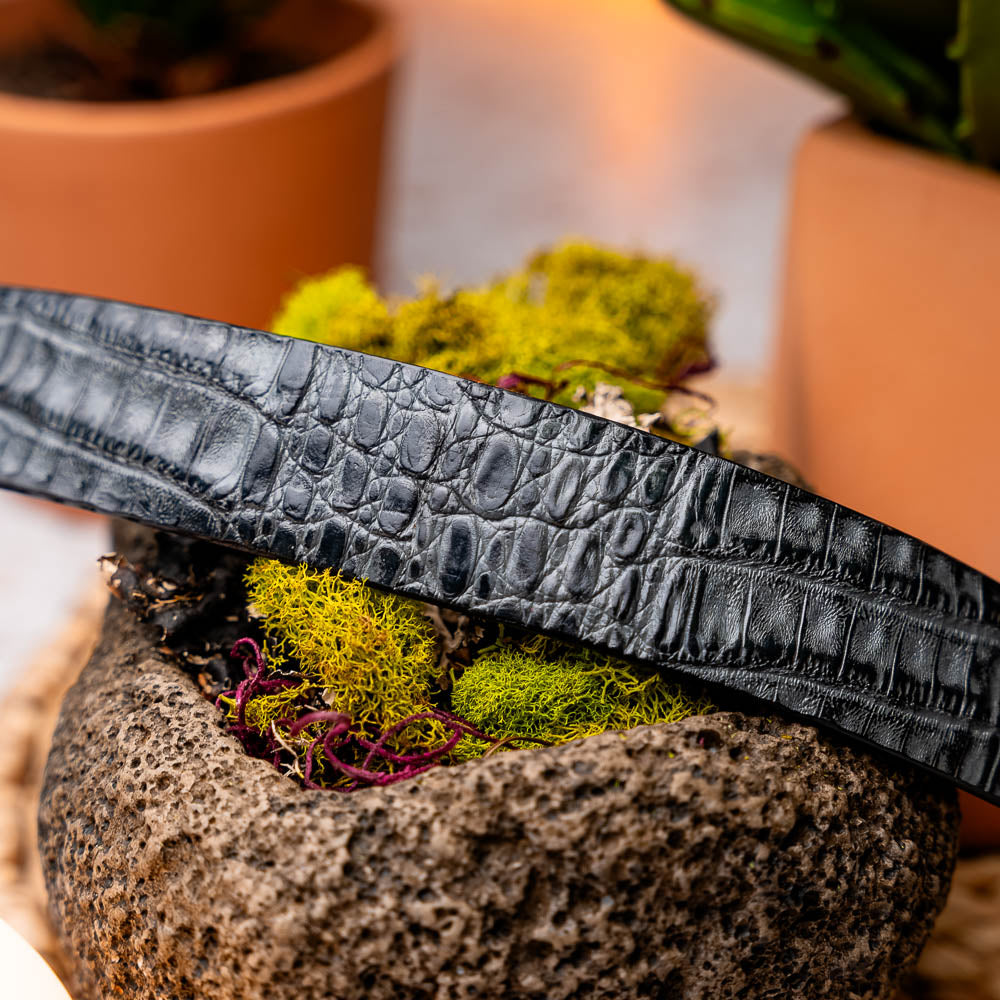 The Riccardo Belt Gray by Marco Di Milano features a genuine caiman fuscus-belly with crocodile pattern, hand-painted finish, and a silver buckle engraved with the brand’s logo—perfect for luxury footwear enthusiasts.