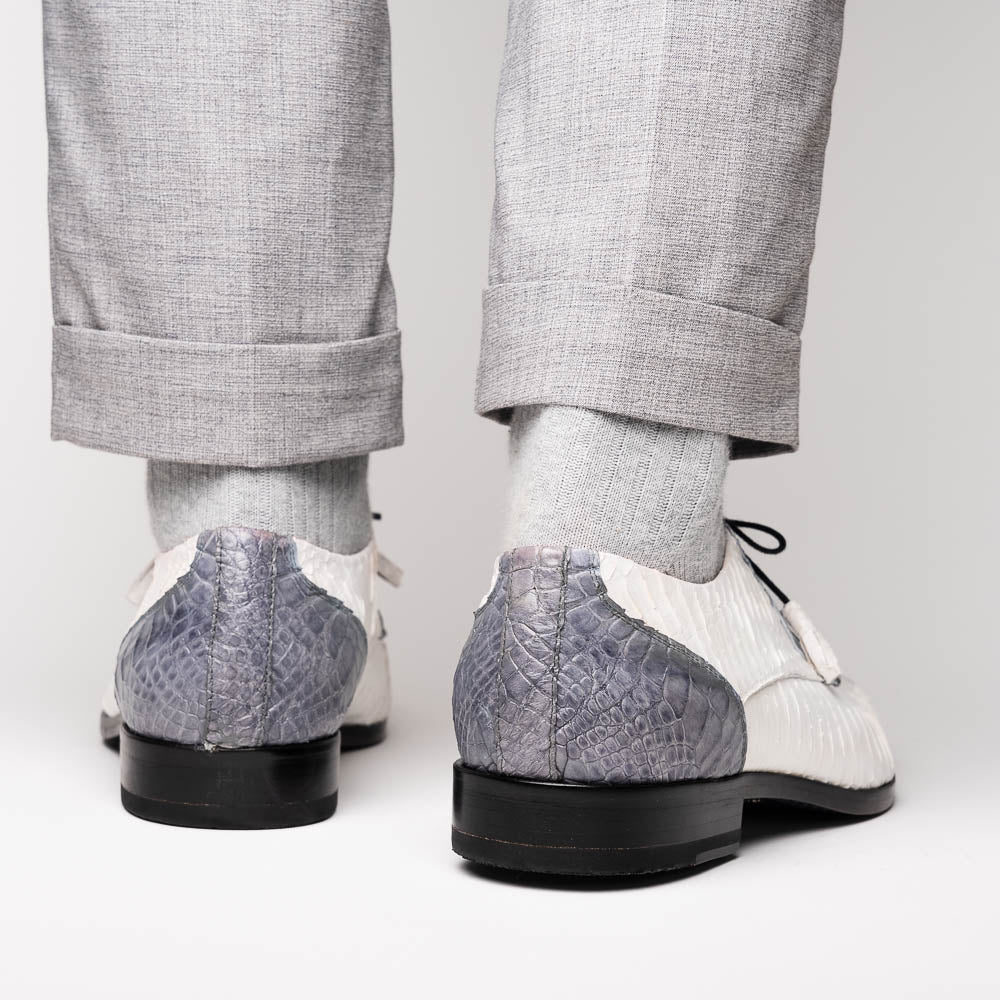 The Marco Di Milano Moncalieri Gray / White men's dress shoes feature a luxury white and grey crocodile pattern, black laces, and black soles, with one shoe stylishly propped against the other.