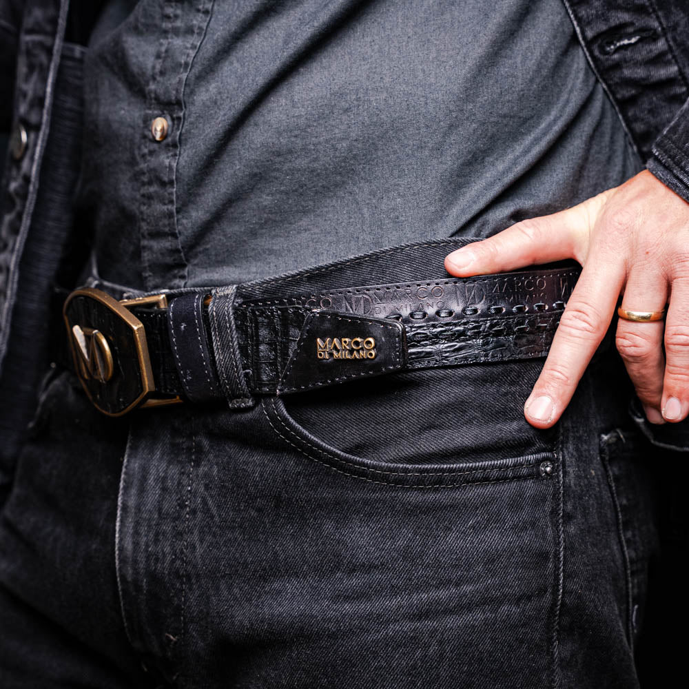 The Marco Di Milano Montana Belt Black features handcrafted black textured leather and a large gold MD monogram buckle, elegantly coiled against a white background.