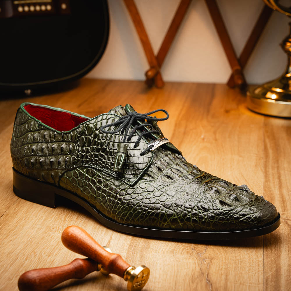 The Nilo Forest Green by Marco Di Milano is a luxury pair crafted from premium Nile crocodile skin in green, with black laces—one shoe upright, the other showing a branded brown leather sole.