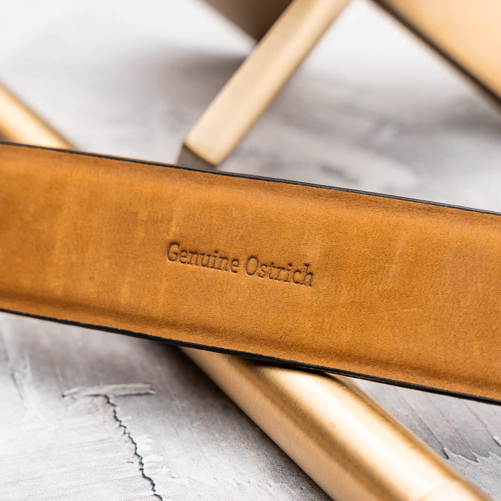 The Domenico Belt Black by Marco Di Milano features black ostrich leather, a silver buckle, and the "MARCO DI MILANO" logo on the metal loop—a sophisticated accessory from the luxury brand Marco Di Milano.