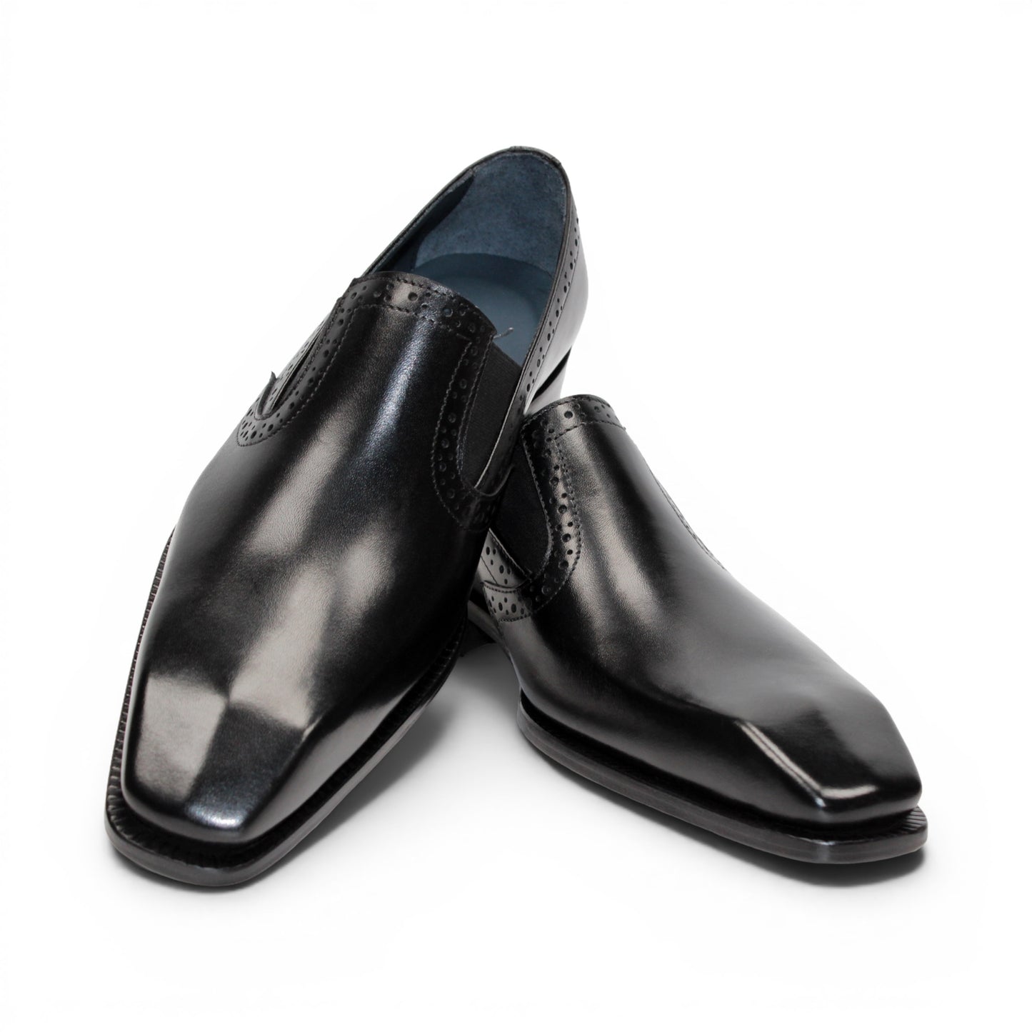 The Duca Di Matiste Duca Paliano Black is an Italian-made slip-on dress shoe in premium black calf leather, featuring a low heel and decorative perforations, shown in profile for timeless style.