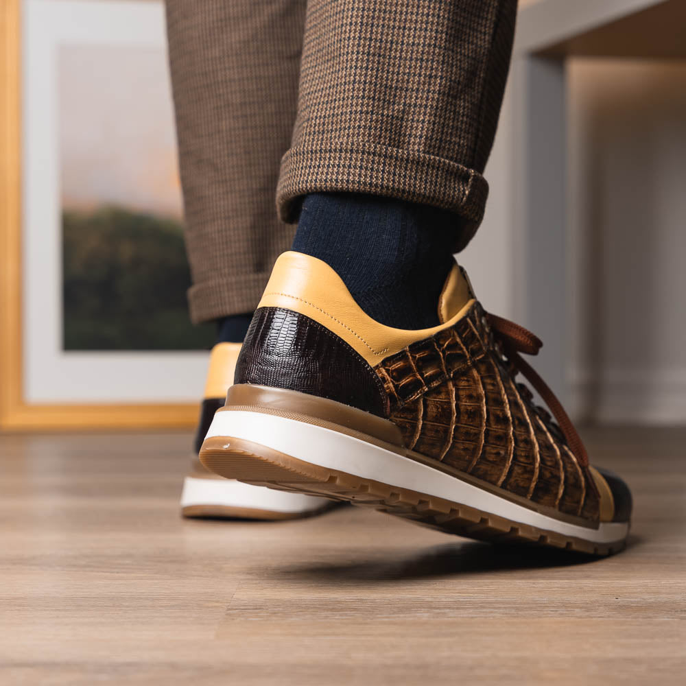 The Portici Orix / Brown by Marco Di Milano features a brown and tan faux crocodile texture, brown laces, white midsole, and a tan-brown rubber sole, delivering luxury style on a white background.