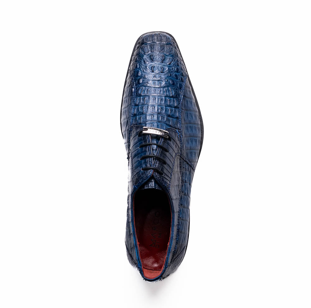 The Marco Di Milano Ragusa Stained Navy is a pair of luxury men's dress shoes in blue crocodile-patterned leather—one upright, one angled to display the sole—handcrafted for sophistication and timeless style.