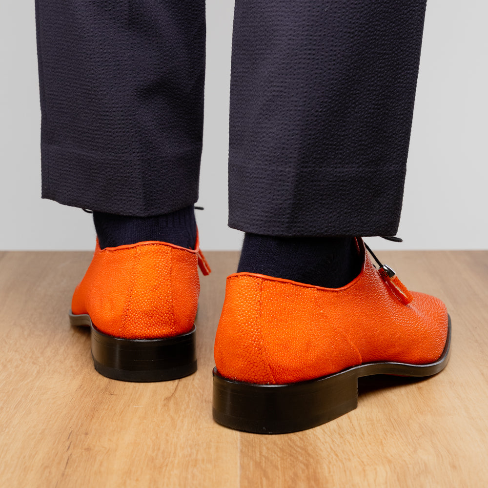 Rimini Orange men’s exotic lace-up dress shoes by Marco Di Milano, expertly crafted from genuine stingray leather in a bright orange hue with black laces; one shoe stands upright while the other lies on its side, showcasing the vibrant red sole and contrasting black heel.