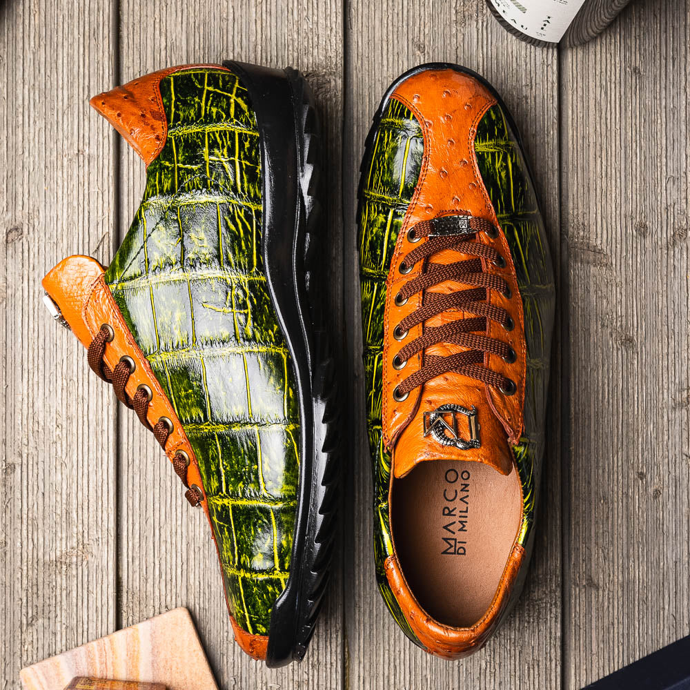 The Saulo Green / Cognac by Marco Di Milano is a luxury men's sneaker with an orange and green crocodile pattern, brown laces, black sole, and metallic tongue emblem—ideal for those wanting an authentic alligator look.