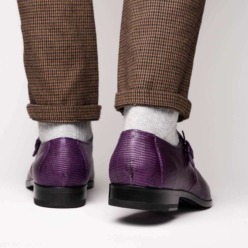 The Toluca Purple by Marco Di Milano is a pair of luxury monk strap shoes with textured purple leather, a silver buckle, red inner lining, and vibrant purple soles—one shoe rests against the other to showcase its unique sole design.