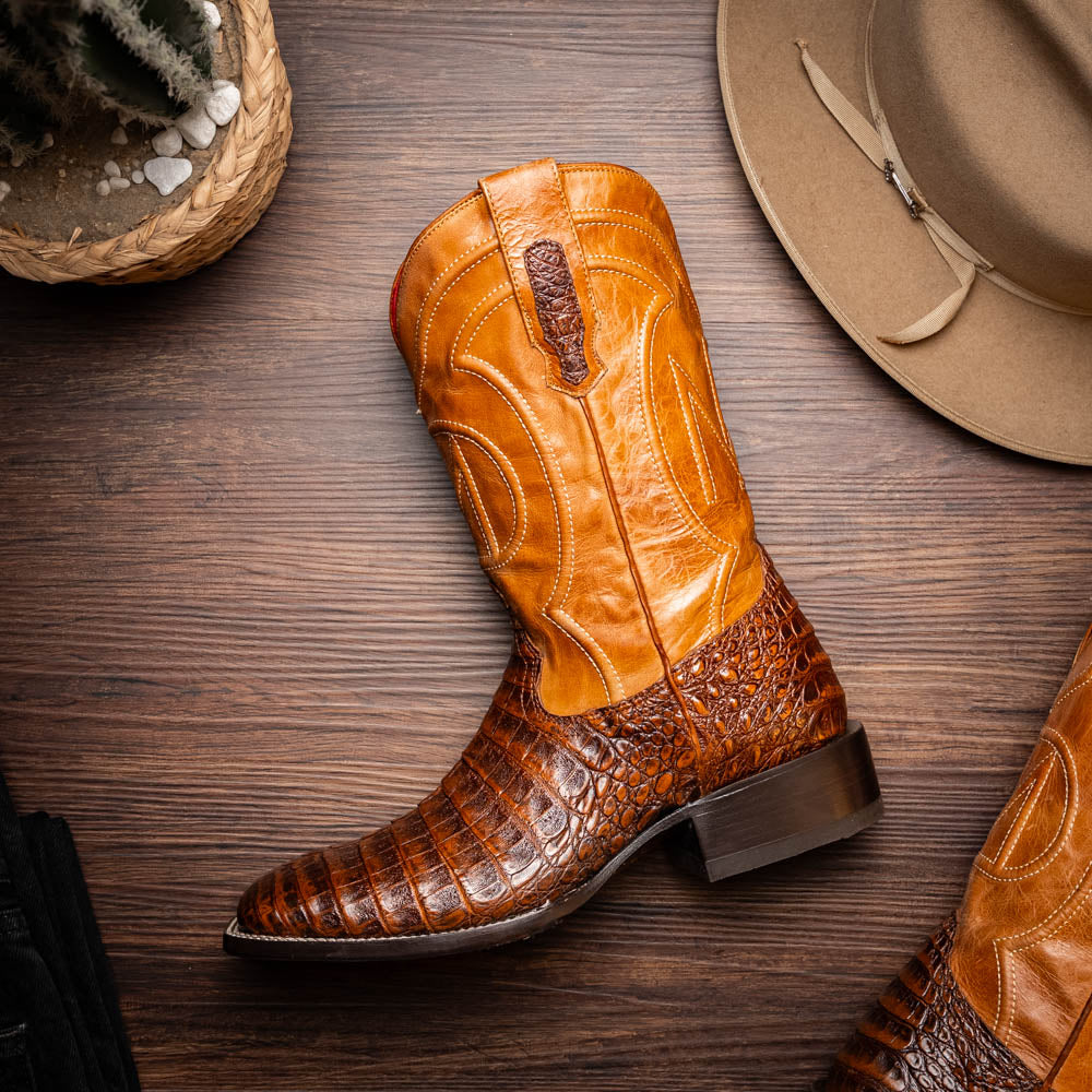 A pair of Tucson Aged Maple brown genuine leather western boots by Marco Di Milano with a textured finish; one boot upright, the other displaying the sole with "Marco Di Milano" branding.