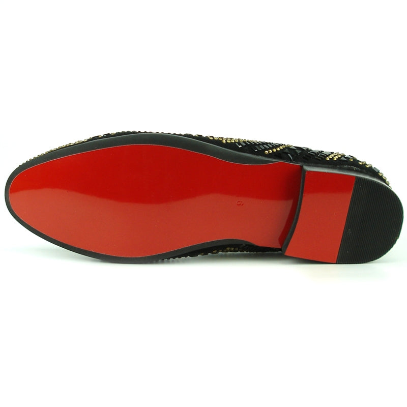 The FI-7220 Black Gold Fiesso by Aurelio Garcia black slip-on shoe features a suede upper adorned with gold and black studs arranged in bold geometric patterns, embodying the essence of a high-fashion shoe.