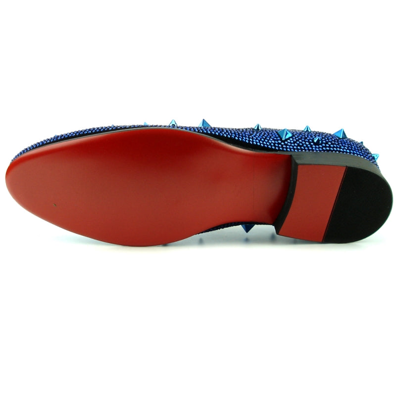 The FI-7364 Black/Blue slip-on shoe by Fiesso showcases a unique blend of elegance and edge with its suede material, small studs, and larger pyramid-shaped spikes.