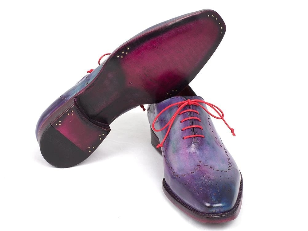 The Paul Parkman Wingtip Oxfords Goodyear Welted Purple - 87PRP11 are expertly crafted, featuring exquisite purple leather with red laces and decorative perforations. Handmade with a Goodyear welted construction, these dress shoes promise both style and durability, making them a standout addition to any wardrobe.