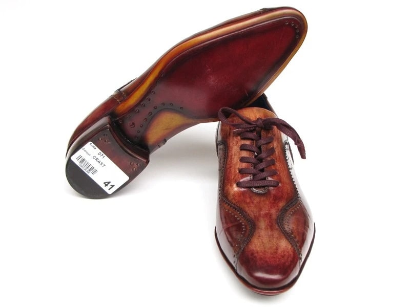 A pair of Paul Parkman Handmade Lace-Up Casual Shoes, known for their polished brown hand-painted finish and crafted from fine Italian calfskin, featuring intricate detailing and dark laces.