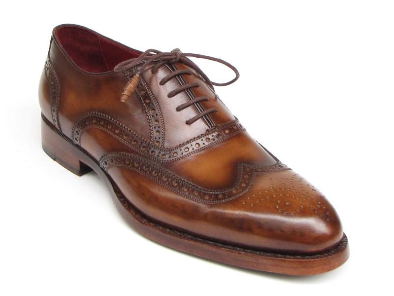 The Paul Parkman Wingtip Oxford Goodyear Welted Tobacco - 027-TAB shoes by Paul Parkman are exquisite handmade brown leather brogues that boast intricate designs and feature laces with Goodyear welted construction. Their elegant wooden soles enhance their appeal, beautifully displayed on a white background.
