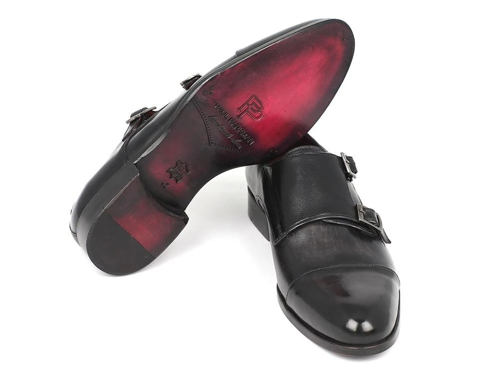 The Paul Parkman Captoe Double Monkstraps Gray & Black - 0457-GRY is gracefully showcased, featuring handcrafted double monk strap shoes with elegant silver buckles and luxurious calfskin leather, with one shoe slightly overlapping the other on a pristine white background.