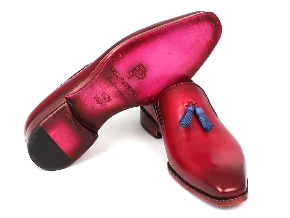 A pair of Paul Parkman Tassel Loafers in a stunning burgundy finish, highlighted with eye-catching blue tassels and complemented by an elegant wooden sole, are showcased beautifully on a pristine white background.