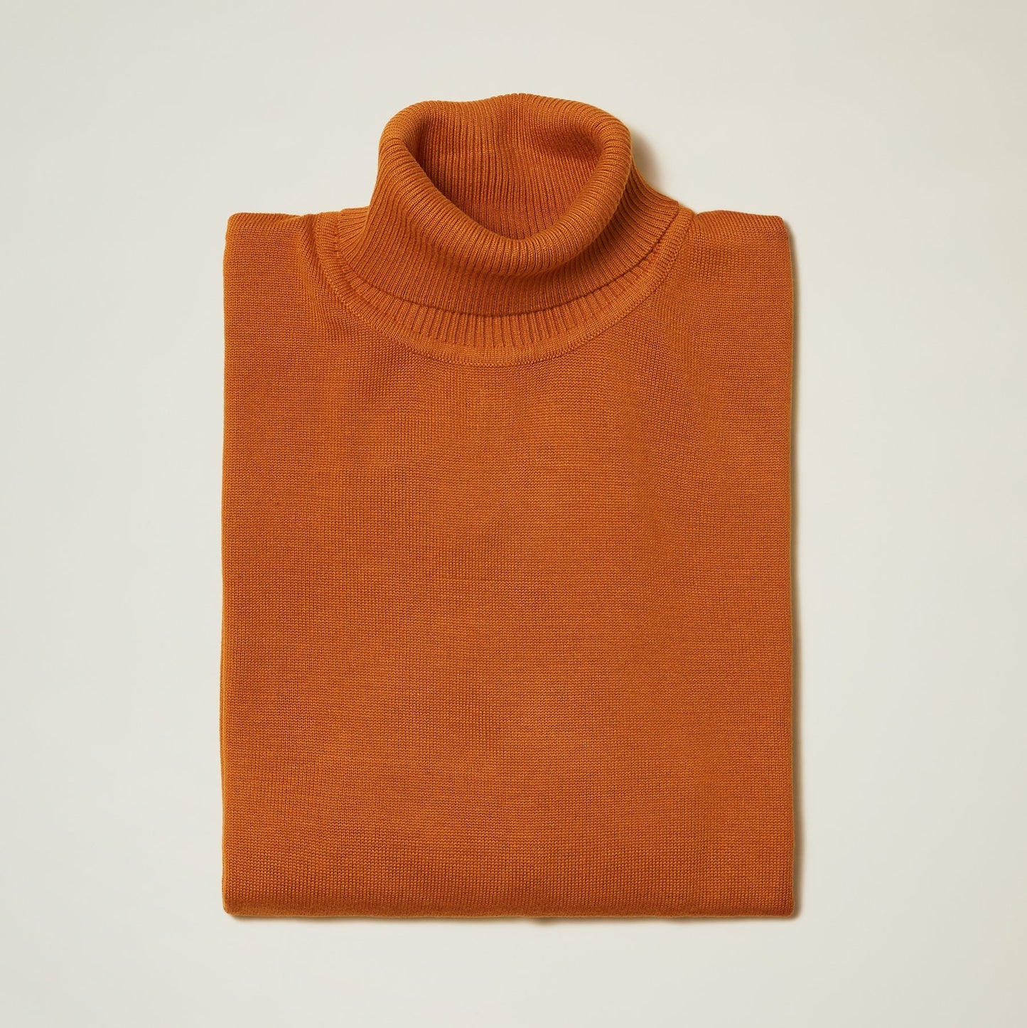 Folded orange Inserch Cotton Blend Turtleneck Sweater 4708, ideal for cozy fall days, showcased on a light background.