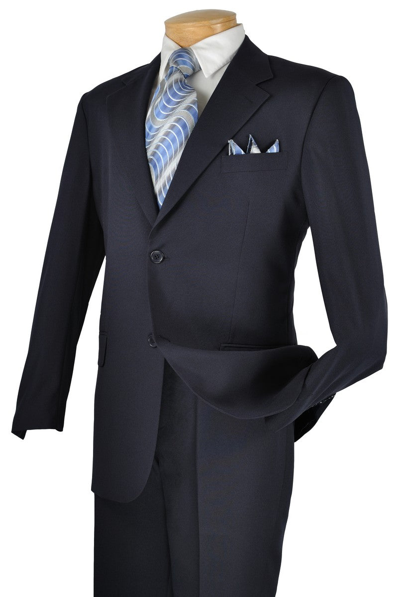 The Vinci Suits Single Breasted Poplin Dacron Suit (Navy) 2PP features a stylish single-breasted jacket with two buttons, paired with a white shirt and blue patterned tie. Flat front pants and a matching pocket square complete the effortlessly elegant look.