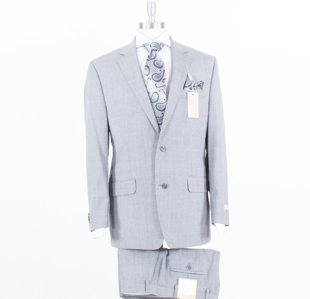 A Michael Kors Modern Fit Grey KEVI2K2Z1220 suit, complete with a paisley patterned tie and pocket square, elegantly displayed on a mannequin against a white backdrop. Tags are attached to the jacket.