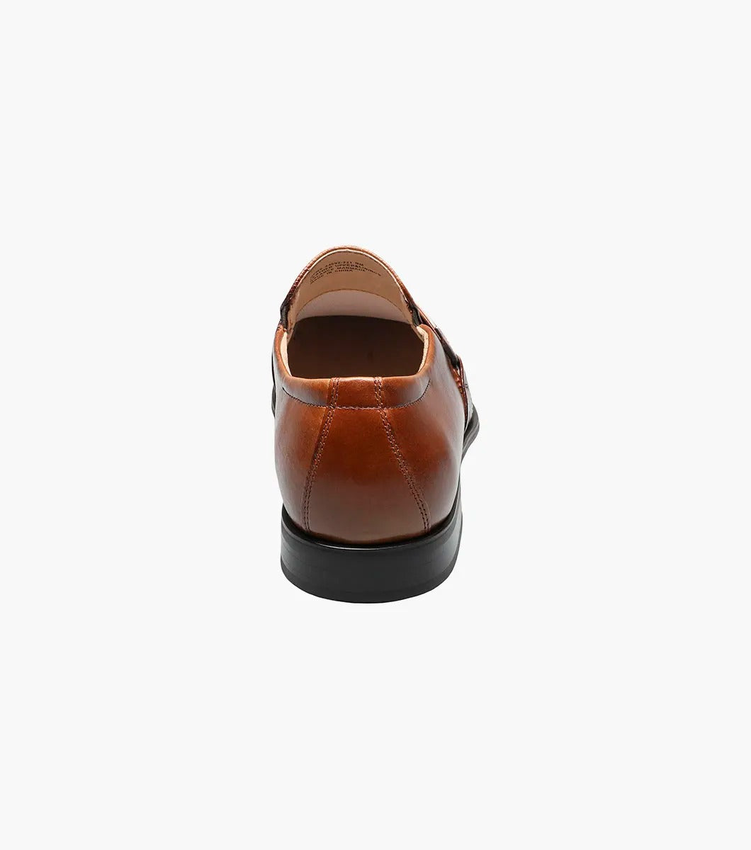 Step into elegance with the Stacy Adams - BEAU Moc Toe Loafer in Cognac, model number 24692-221. This sophisticated loafer spotlights a textured vamp, chic buckle detail, and a contrasting black sole. The premium leather upper elevates its design, while the cushioned insole provides all-day comfort for a stylish yet comfortable experience.