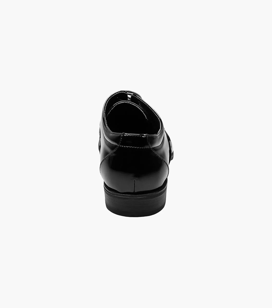 The Stacy Adams GALA Cap Toe Oxford dress shoe, model 24998-004, showcases a sleek design crafted from shiny black patent leather. It features a low heel and memory foam cushioning for enhanced comfort, elegantly displayed on a white background.