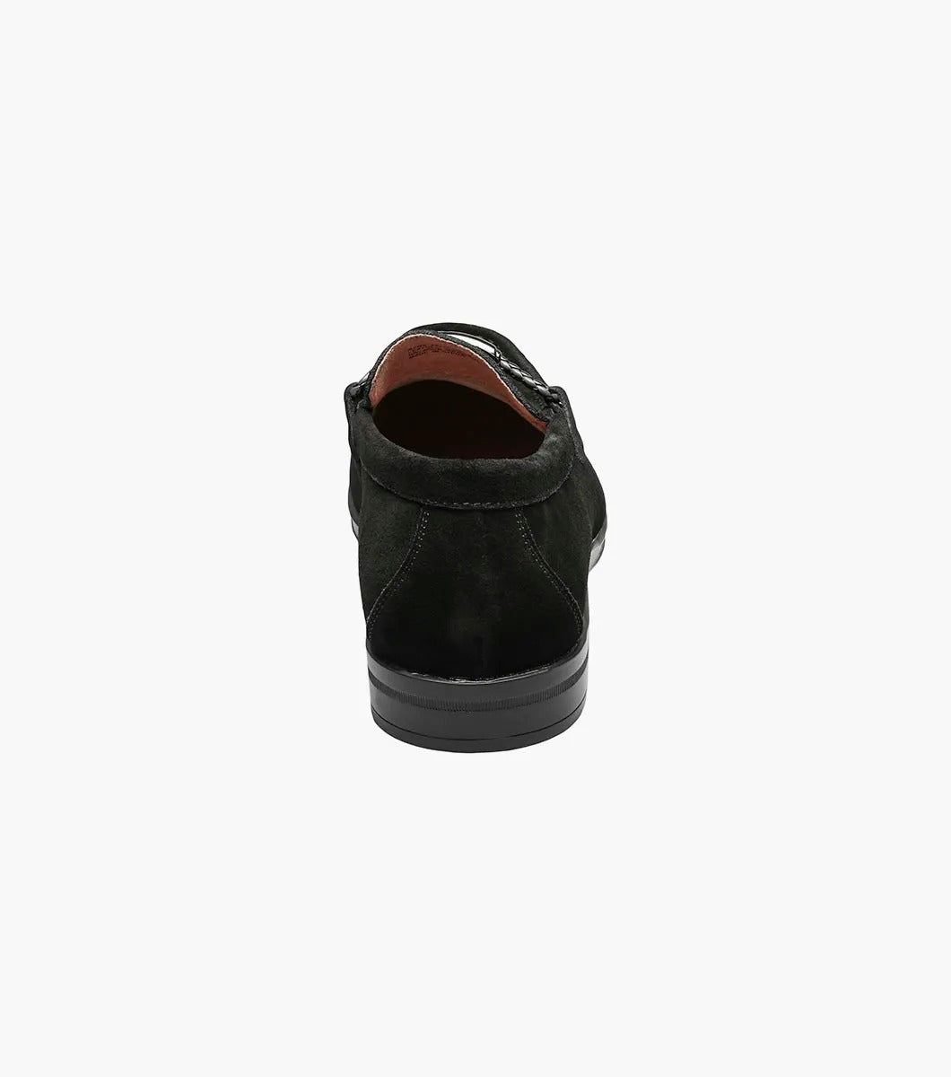 The Stacy Adams Neville Moc Toe Bit Slip On (Black Suede, 25224-008) features a silver metal bit, visible stitching, low heel, tan lining, and a Memory Foam cushioned insole for comfort.