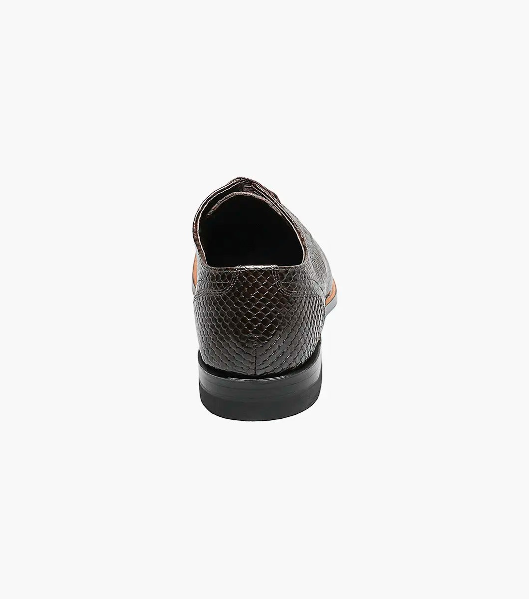 The STACY ADAMS Madison Anaconda Plain Toe Oxford in brown (00055-200) is shown at an angle, highlighting its glossy anaconda print leather, textured snakeskin pattern, black sole, and classic Goodyear welt construction.