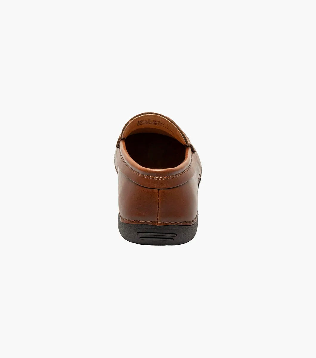 The Stacy Adams Del Moc Toe Loafer in brown (style 25533-200) features a black rubber sole, visible stitching, and striped interior lining, shown on a plain white background.