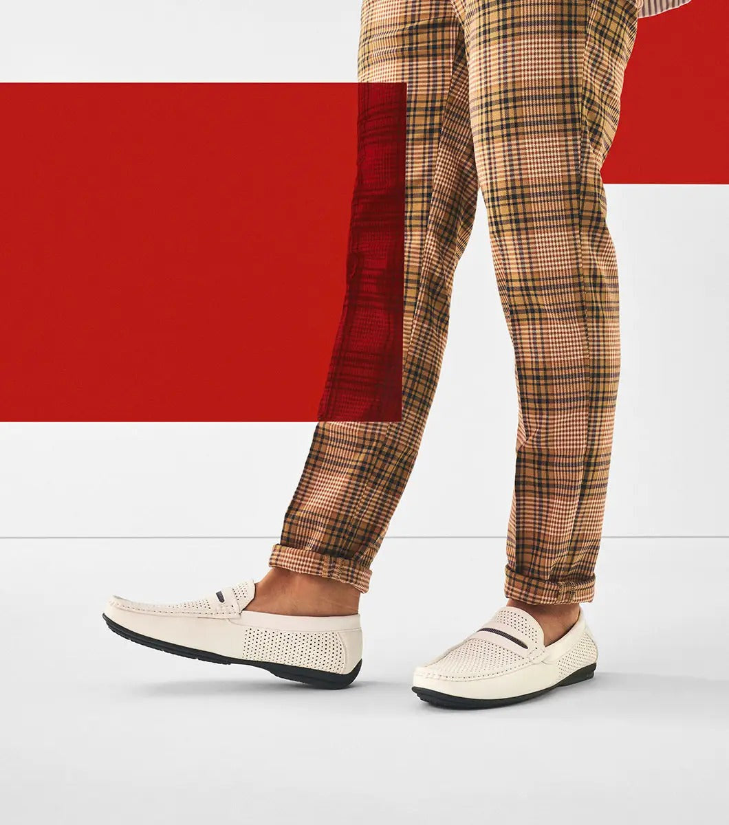 Stacy Adams' CORBY Moc Toe Saddle Slip On in white (25513-100) features a perforated design with a penny strap, pointy toe, and layered sole, making it the perfect casual shoe for warm weather. The loafer is displayed against a plain background.