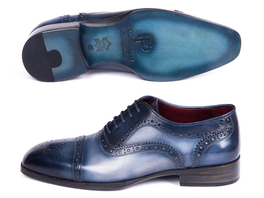 The Paul Parkman Cap Toe Oxfords Blue & Navy - 024-NVYBLU, crafted by Paul Parkman, are hand-painted leather shoes with decorative perforations and laces, elegantly displayed on a white background.