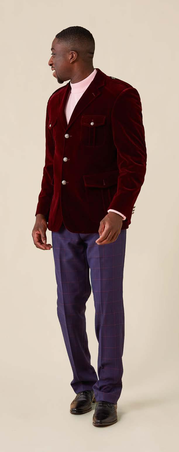 A man wearing the Inserch Velvet Military Blazer BL569-31 in burgundy, paired with a beige turtleneck and jeans.