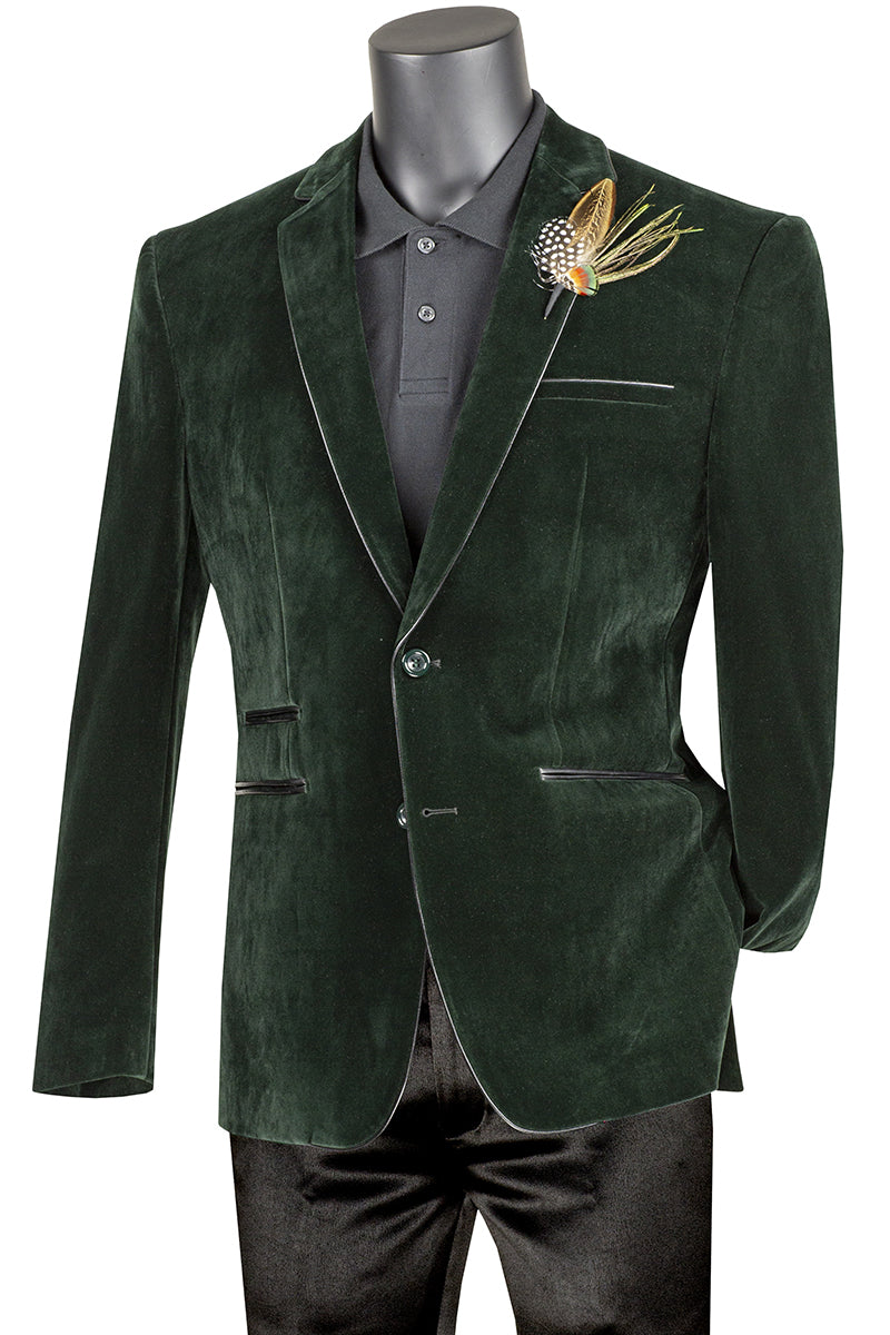 The Slim Fit Velvet Sport Coat (Emerald) BS-02 by Vinci Suits features an elegant slim fit, a black button-up shirt, and a decorative brooch on the lapel for a stylish silhouette.