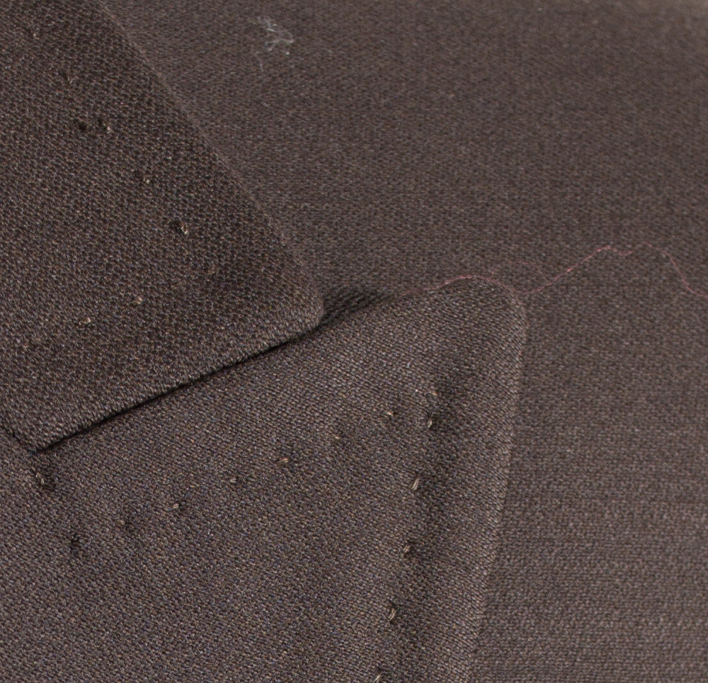 The Tiglio Rosso San Giovesse Brown TIG1003 three-piece suit, crafted from 100% wool, is paired with a light blue dress shirt, an orange patterned tie, and a matching pocket square.