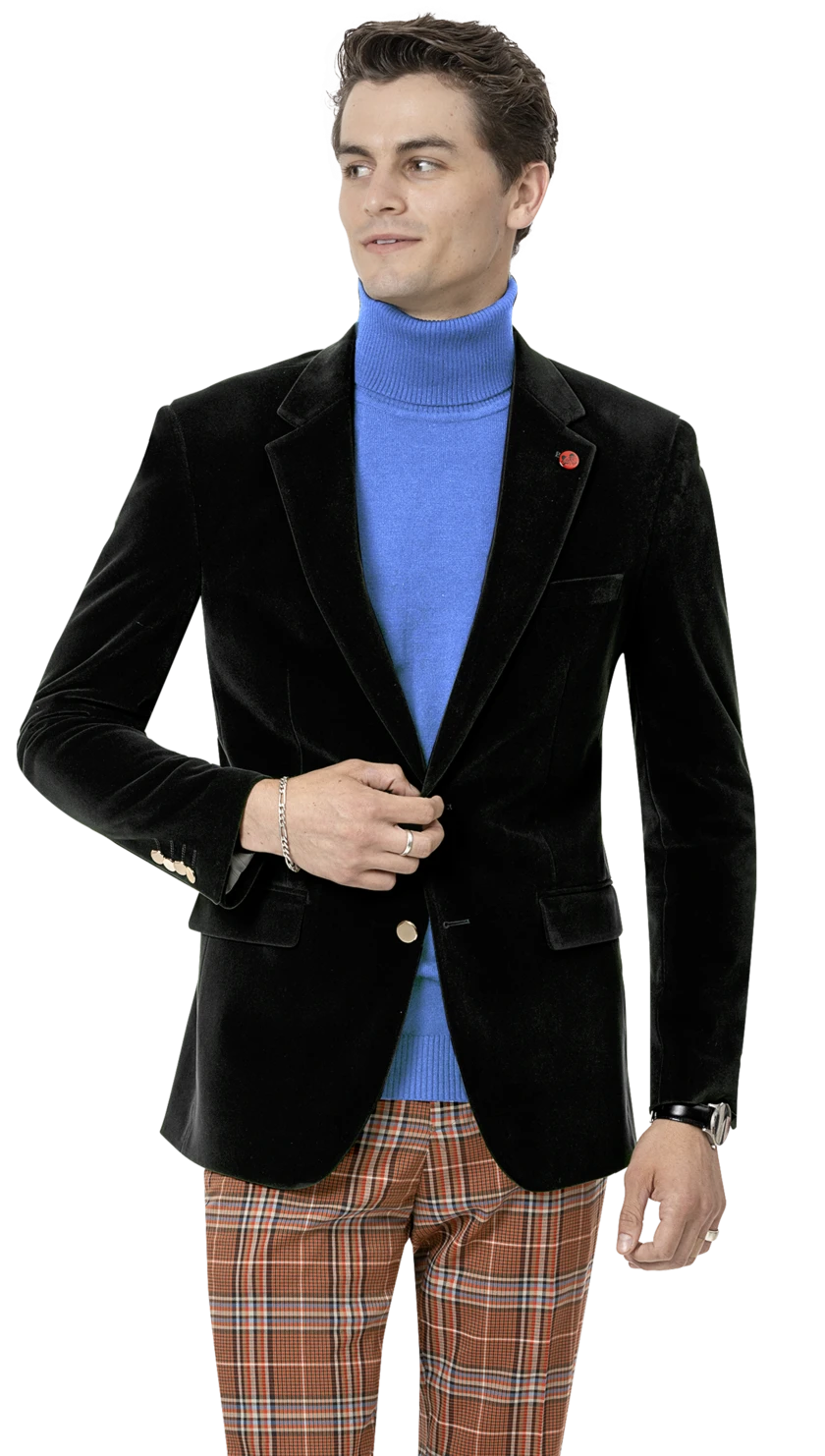 A person wearing an EJ SAMUEL Black Velvet Blazer J134 with gold buttons, a blue turtleneck, and plaid pants holds the blazer button while looking to the side.