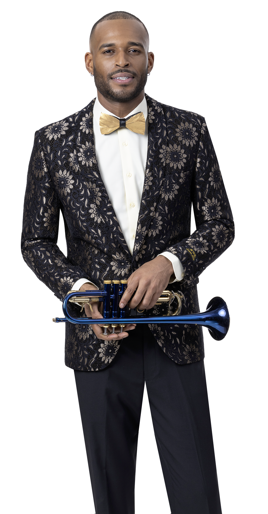 A man in an EJ Samuel black and gold lace blazer, adorned with floral patterns, complemented by a gold bow tie and gold underlay flowers, holds a blue trumpet.