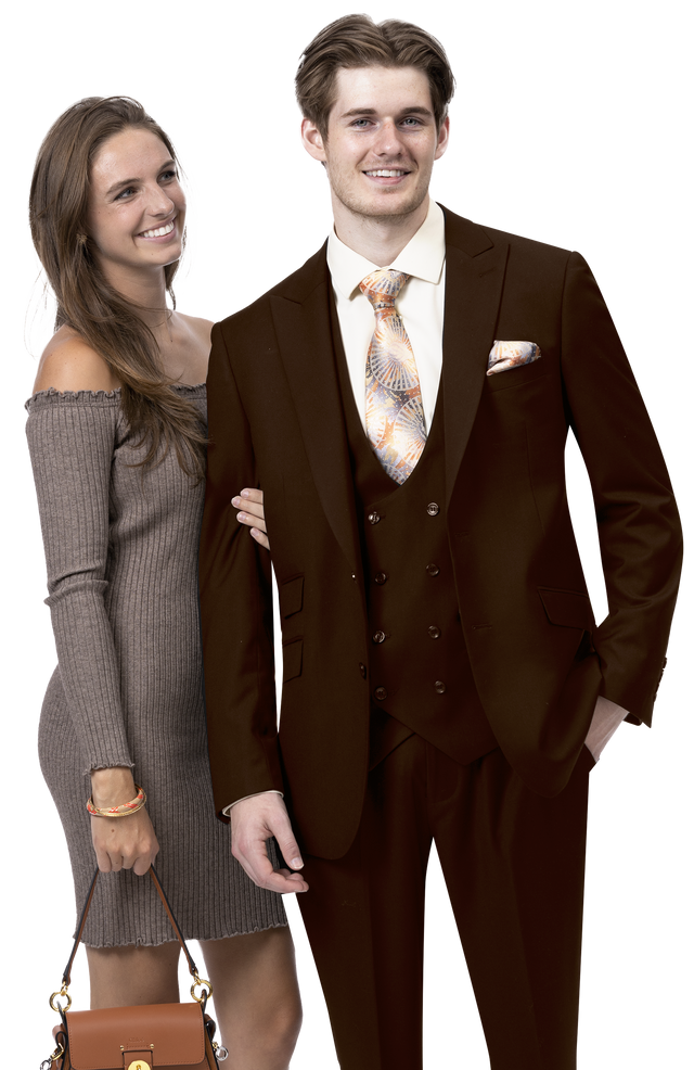 A man in an EJ Samuel Brown Suit M2770, complemented by a patterned tie, stands smiling alongside a woman wearing a solid gray dress and holding a small handbag.