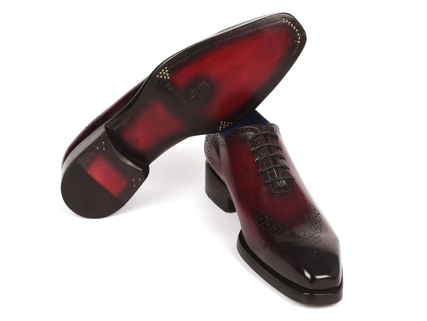 The Paul Parkman Goodyear Welted Punched Oxfords Bordeaux (Model 7614-BRD) boast a luxurious design with burnished hand-painted calfskin in dark red, a stylish blue interior, intricate perforated details, stacked heels, and a durable Goodyear welted construction.
