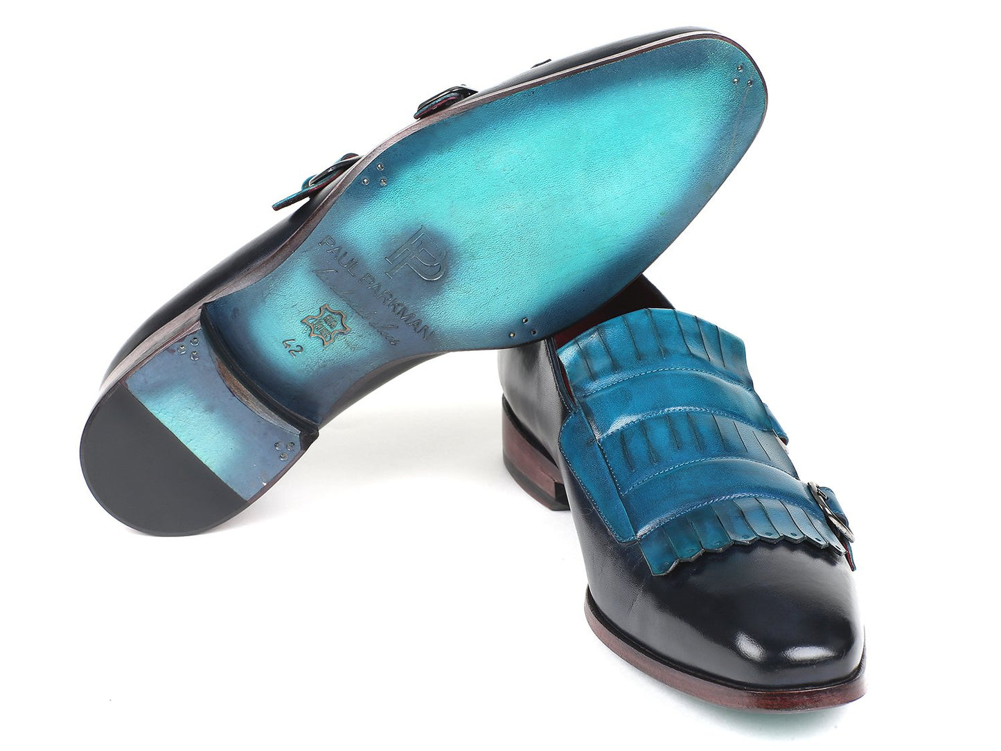 Introducing the Paul Parkman Blue & Navy Kiltie Double Monkstraps (ST17BLU), exquisite black leather dress shoes featuring blue fringed accents and red soles, skillfully hand-painted for a distinctive finish.