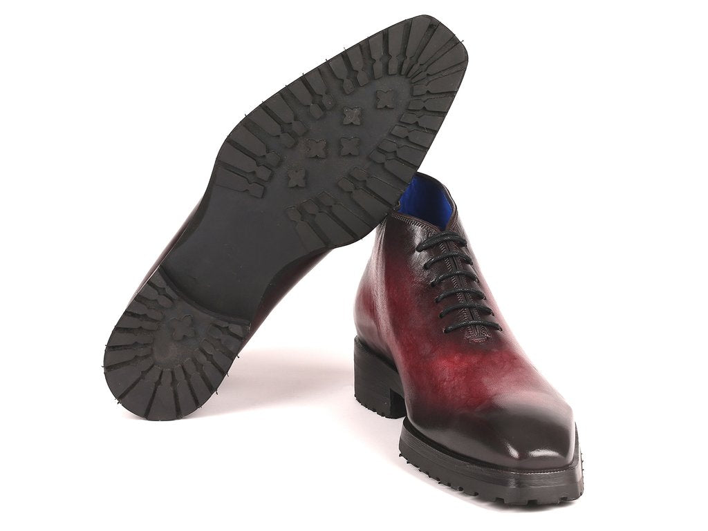 A pair of Paul Parkman Ankle Boots in a Bordeaux burnished finish, featuring a shiny, red and black gradient design, lace-up style with hand-painted leather, and black chunky soles, arranged artistically on a white background.