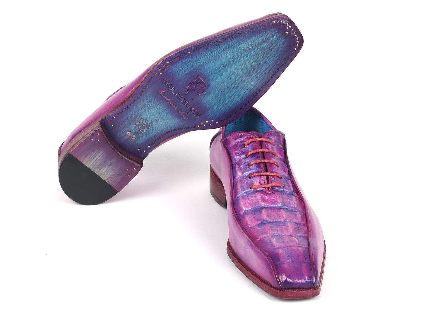 Introducing the Paul Parkman Purple Croco Textured Leather Bicycle Toe Oxfords - 94-277: a pair of handmade shoes crafted from shiny, lizard skin leather in a striking purple hue. Designed with a bicycle toe, these luxurious oxfords feature intricate blue lining and vibrant pink laces, elegantly displayed against a clean, white background.