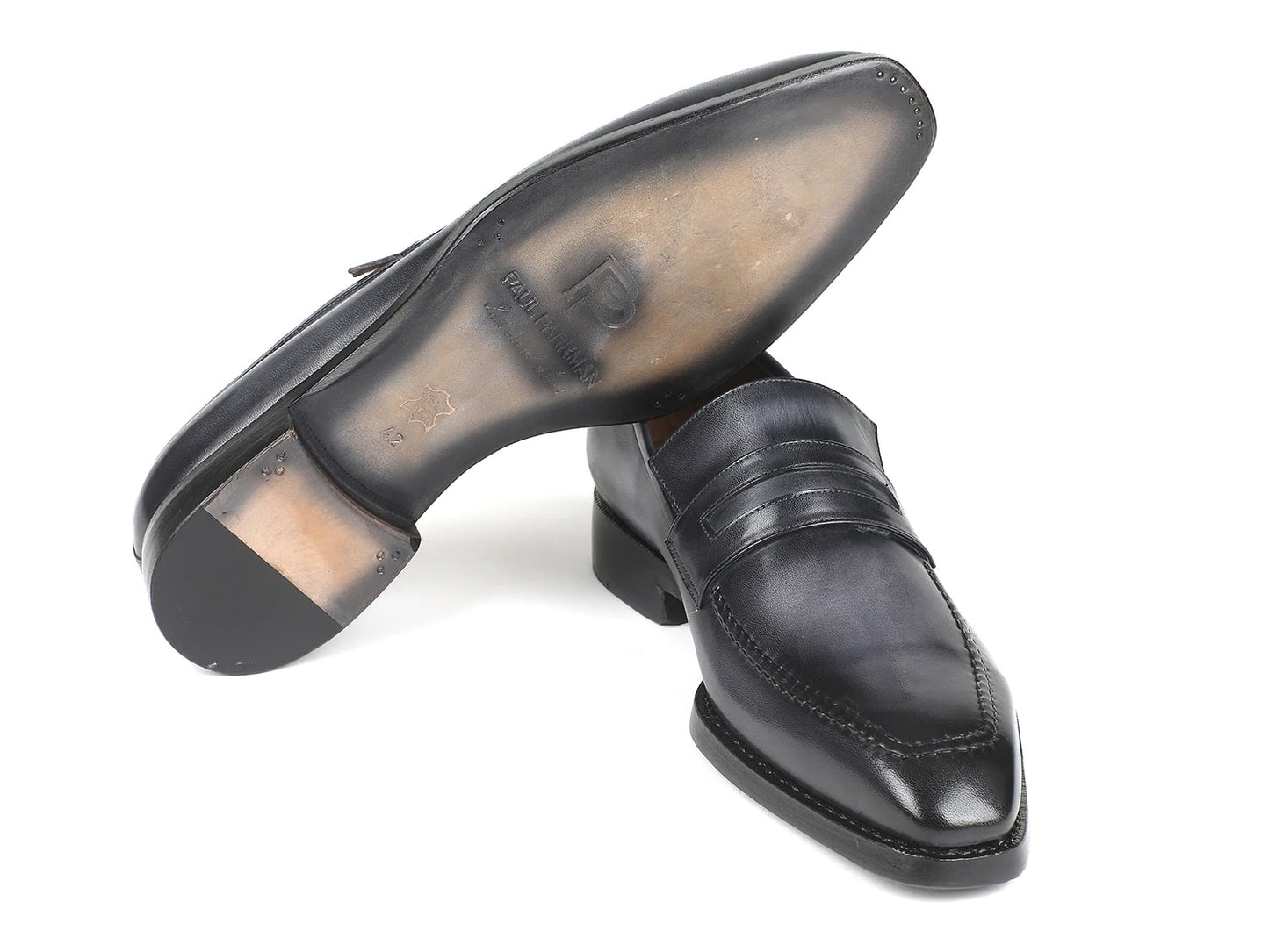 A pair of Paul Parkman Gray Burnished Goodyear Welted Loafers featuring stitched detailing and a sleek finish, crafted from hand-painted calfskin leather, with one shoe elegantly placed atop the other.