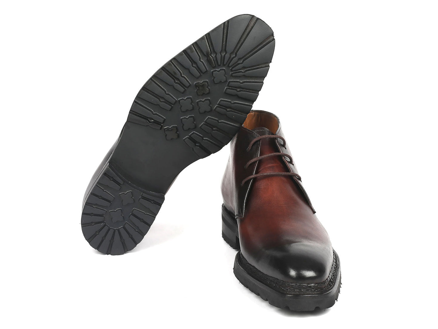 A pair of Paul Parkman Norwegian Welted Chukka Boots in Brown Burnished, featuring black soles and laces, displayed against a plain white background, expertly crafted from hand-painted leather.