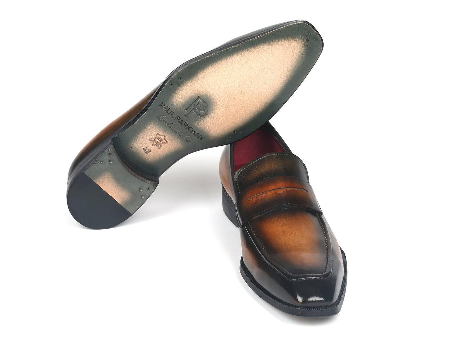 The Paul Parkman Penny Loafers Olive Brown - 10LZ24, crafted by the renowned brand Paul Parkman, display a refined elegance with their sleek design and dark toe accents. These polished olive brown leather loafers, featuring a striking red interior, are expertly made-to-order for the discerning gentleman and are elegantly positioned diagonally against a white background.