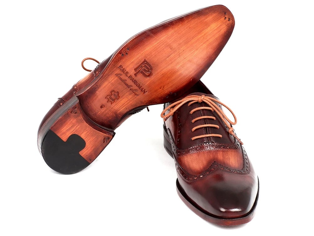 The Paul Parkman Two Tone Wingtip Oxfords - PP22TX54, elegant dress shoes by Paul Parkman, are crafted from hand-painted brown leather and feature intricate brogue detailing along with tan laces.