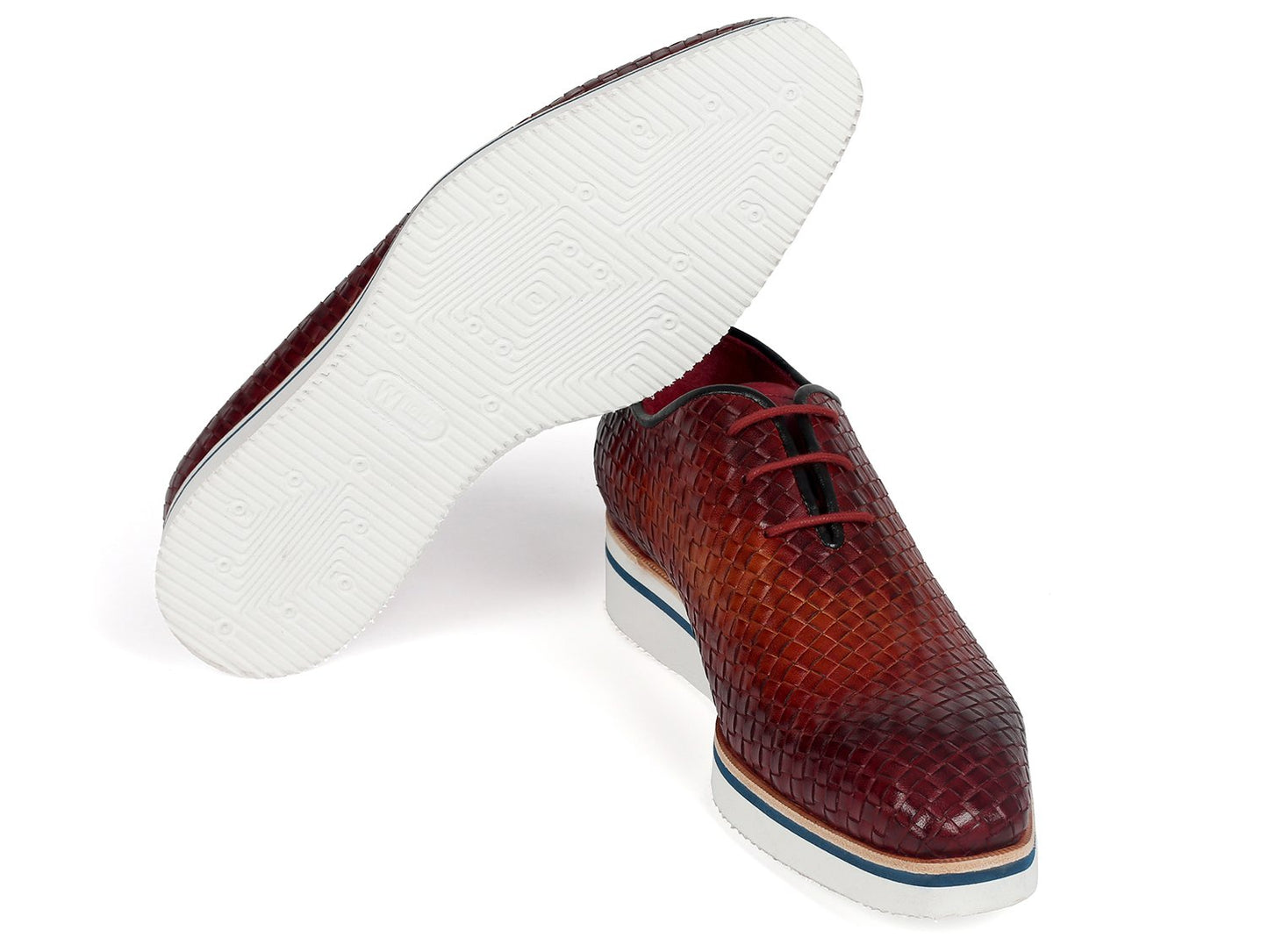 The Paul Parkman Brown Woven Leather Smart Casual Shoes (182-RDH-BRW) showcase a textured, woven leather upper complemented by white platform soles and blue accents. One shoe is elegantly positioned standing on its heel, emphasizing the unique design of this made-to-order product from Paul Parkman.