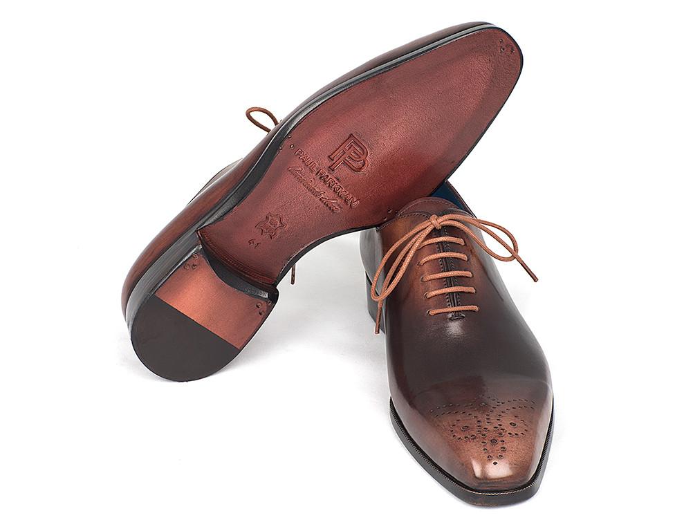 A pair of Paul Parkman Camel & Brown Wholecut Oxfords – KR254CML, exquisitely handmade with antique finished leather and adorned with decorative perforations and laces, elegantly displayed on a white background.