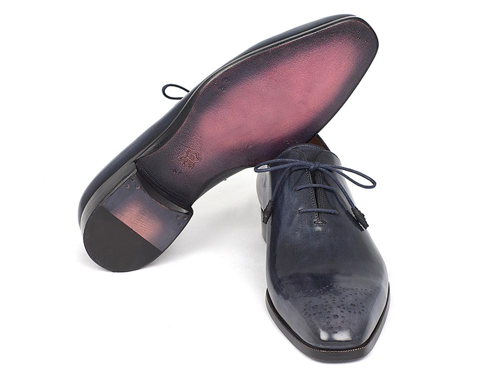 The Paul Parkman Navy Wholecut Oxfords - KR254NVY are a pair of handmade shoes crafted in glossy navy calfskin, complete with laces and decorative perforations on the toes.