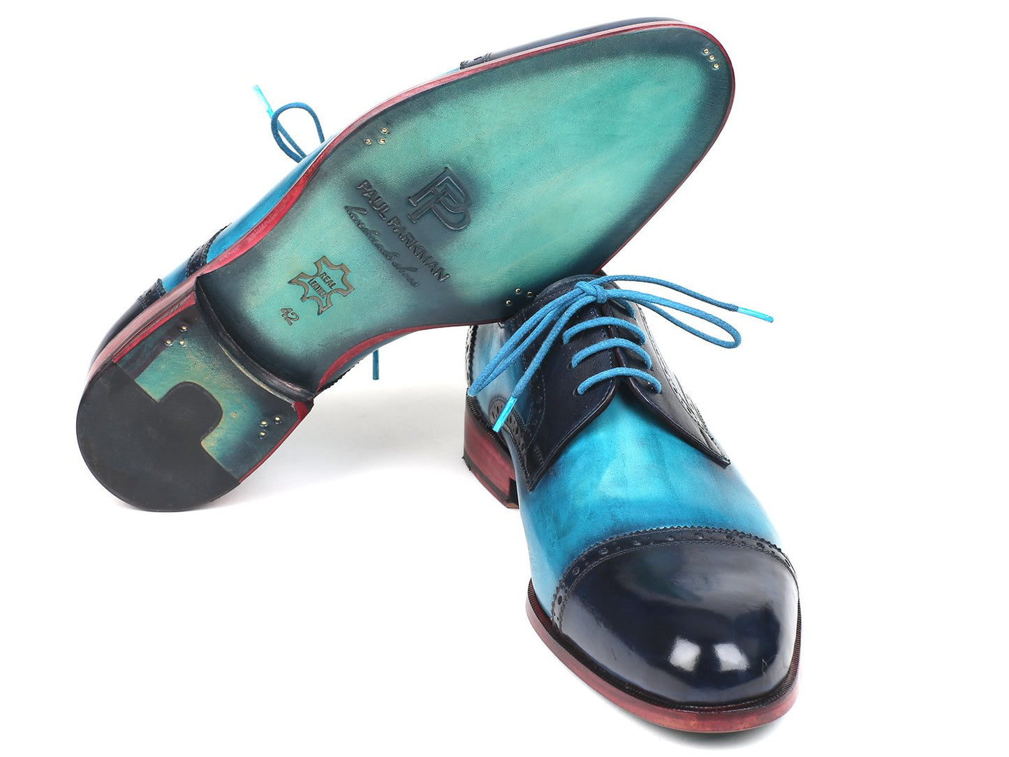 A pair of Paul Parkman Two Tone Cap-Toe Derby Shoes in blue and turquoise leather, featuring brogue detailing and blue laces, displayed with a polished finish on a white background.